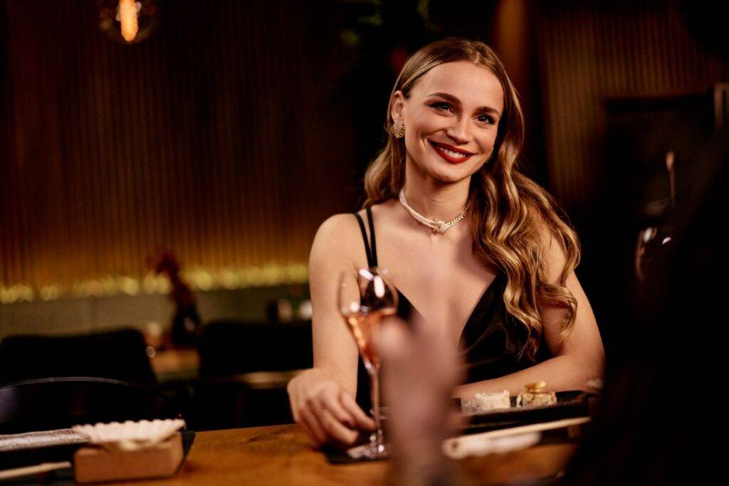 Charmante Frau bei einem gehobenen Dinner – zeigt den sozialen Aspekt der Tätigkeit beim Escort werden in Hamburg.