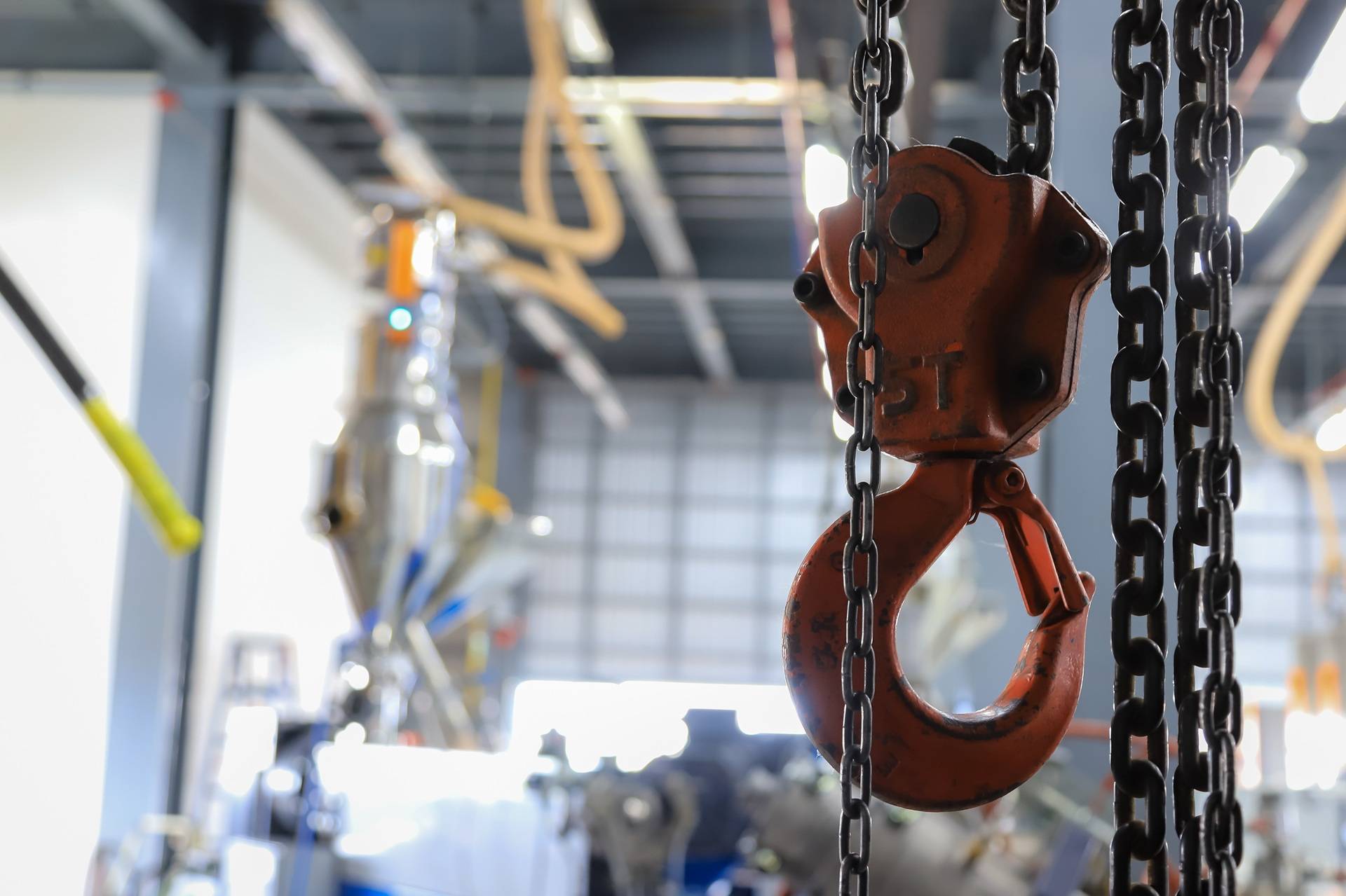 Roter Lasthaken mit Kette in Produktionshalle | Elektroseilwinde